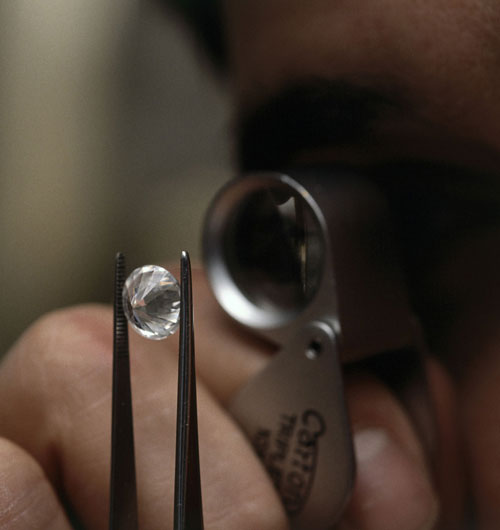 person inspecting diamond